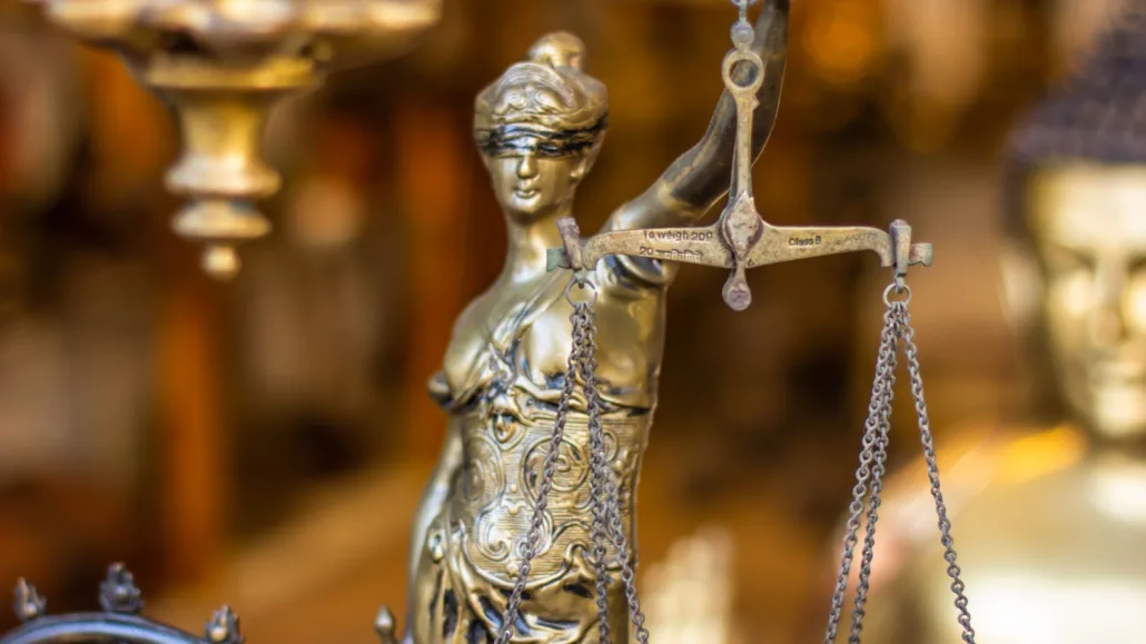 Bronze Lady Justice statue with scales - defense against sexual harassment charges in Austria